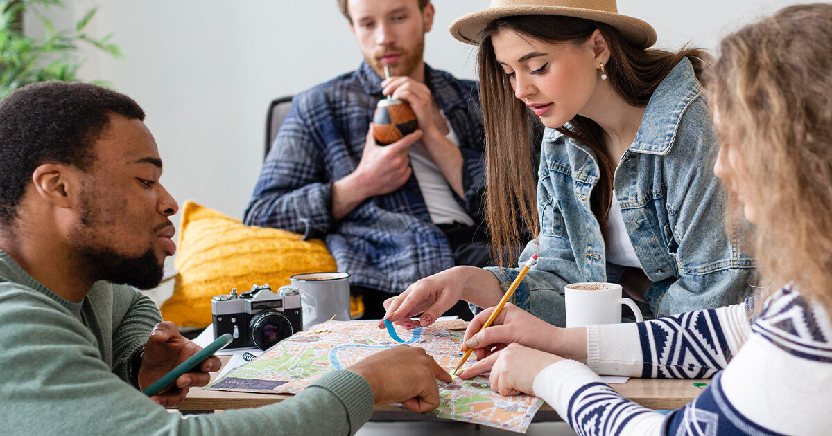 Group of friends looking at map on coffee table.